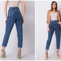 Kobieta w jeansach mom fit, które podkreślają talię i luźno opadają na nogi. To styl, który pokochały kobiety.