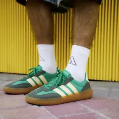 Zielone sneakersy Adidas z żółtymi paskami i brązową podeszwą. Idealne na 18 stopni, gdy chcesz wyglądać stylowo i czuć się komfortowo.
