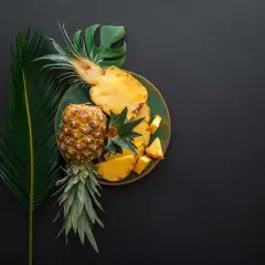 Ananas na talerzu, obok liści. Czy wiesz, że bromelaina co to za enzym? Pomaga w trawieniu.