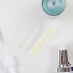 Delikatne kosmetyki z kwasem laktobionowym w ciąży. Próbki serum i kremów, pipeta i pompki dozujące.