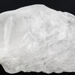 Surowy, biały ałun, minerał o krystalicznej strukturze, wygląda jak zamarznięta bryła lodu.