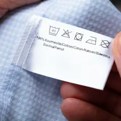 Metka z instrukcjami prania. Widoczny symbol wirowania na metce informuje o maksymalnej temperaturze wirowania.
