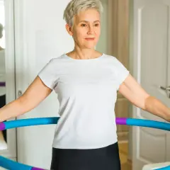 Kobieta ćwiczy z hula hop, widoczne efekty po 2 tygodniach.