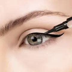 Precyzyjne wykonanie kociego oka makijaż. Czarny eyeliner podkreśla kształt oka, tworząc uwodzicielskie spojrzenie.