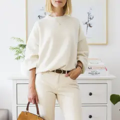 Eleganckie biały sweter stylizacje: luźny sweter, beżowe spodnie, brązowy pasek i torebka.