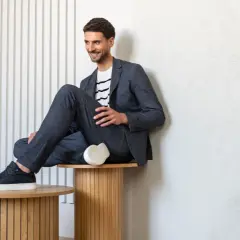 Mężczyzna w granatowym garniturze i białej bluzce w paski, prezentujący styl smart casual męski.