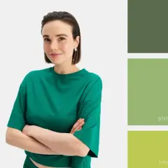 Modelka w zielonej bluzce prezentuje paletę odcieni zieleni: khaki, pistacjowy, limonkowy, butelkową i szmaragdową. Inspiracja, z czym łączyć zielony kolor ubrania.