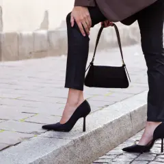 Eleganckie czarne szpilki to idealne buty do wąskich spodni damskich. Stylizacja uzupełniona o czarną torebkę.