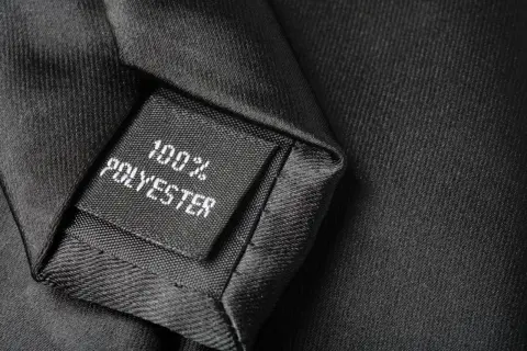 Czarna metka na krawacie informuje: 100% poliester. To materiał, z którego jest wykonany.