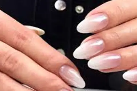 Eleganckie paznokcie ombre french w odcieniach bieli i różu, subtelnie przechodzące w perłowy blask.