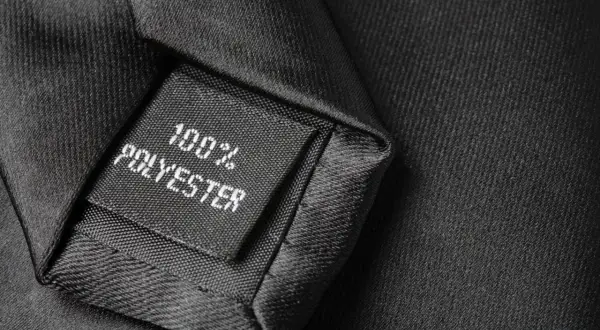 Czarna metka na krawacie informuje: 100% poliester. To materiał, z którego jest wykonany.