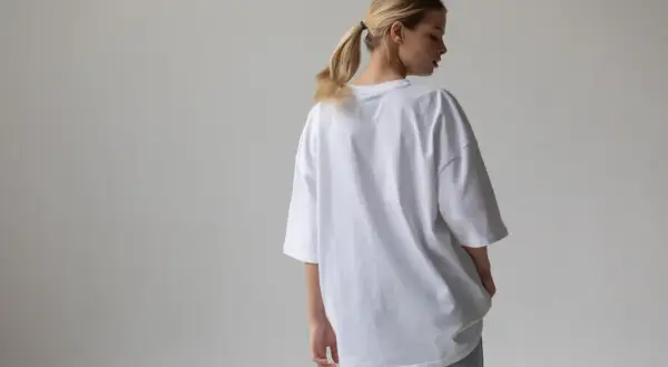 Dziewczyna w białej koszulce oversize, która jest luźna i wygodna. To właśnie oznacza oversize – swobodny krój.