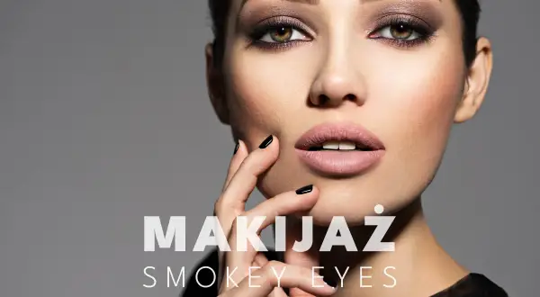 Delikatny makijaż smoky eyes podkreśla spojrzenie. Kobieta zmysłowo dotyka twarzy.