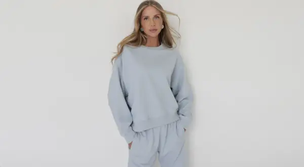 Kobieta w błękitnym, luźnym dresie. Eleganckie dresy stylizacje to komfort i szyk w jednym.