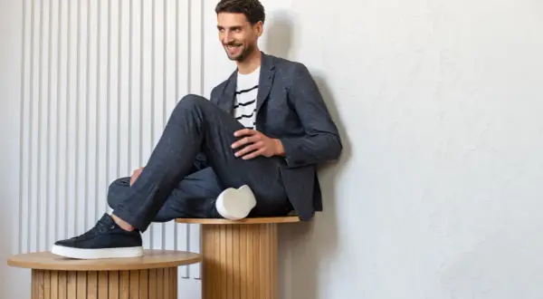 Mężczyzna w granatowym garniturze i białej bluzce w paski, prezentujący styl smart casual męski.