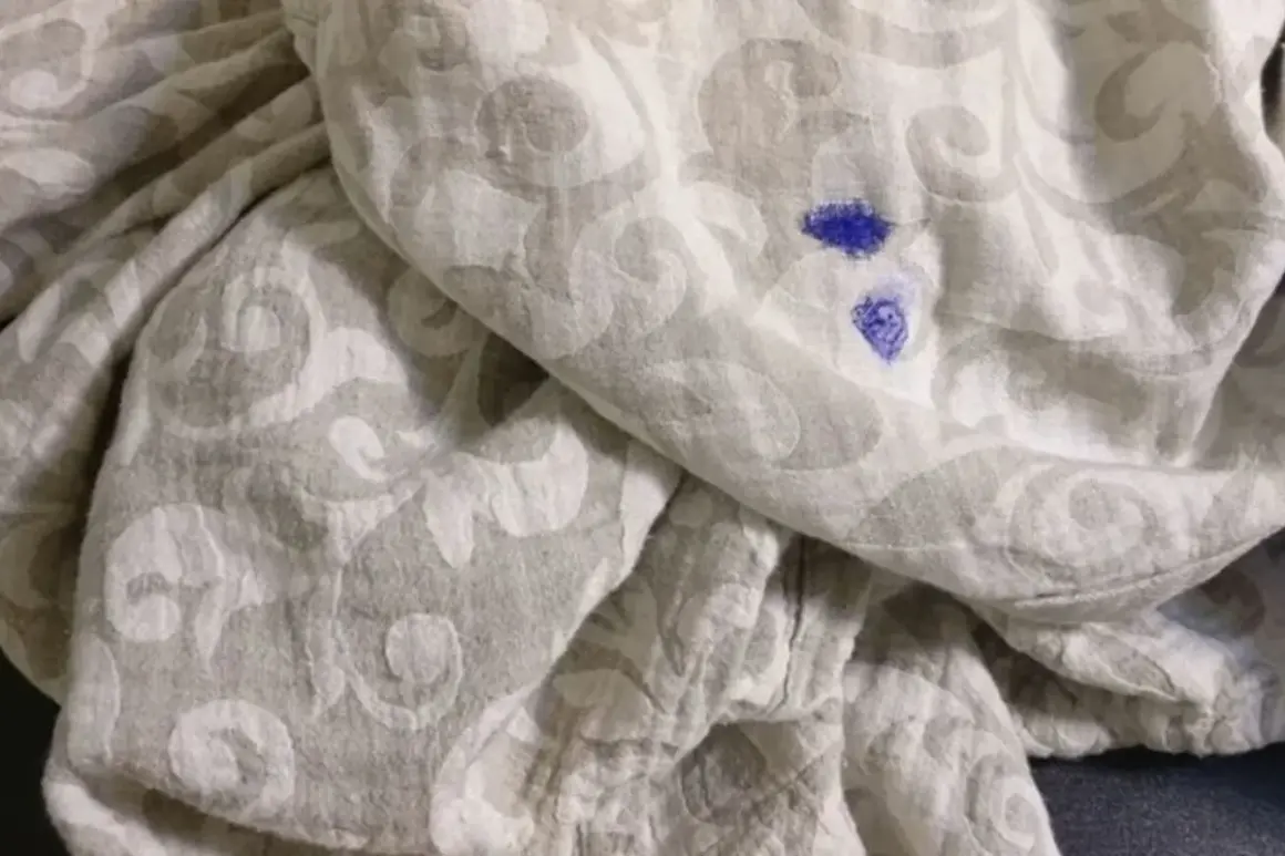 Niebieska plama po markerze na jasnej tkaninie z wzorem. Jak zmyć marker z ubrań?