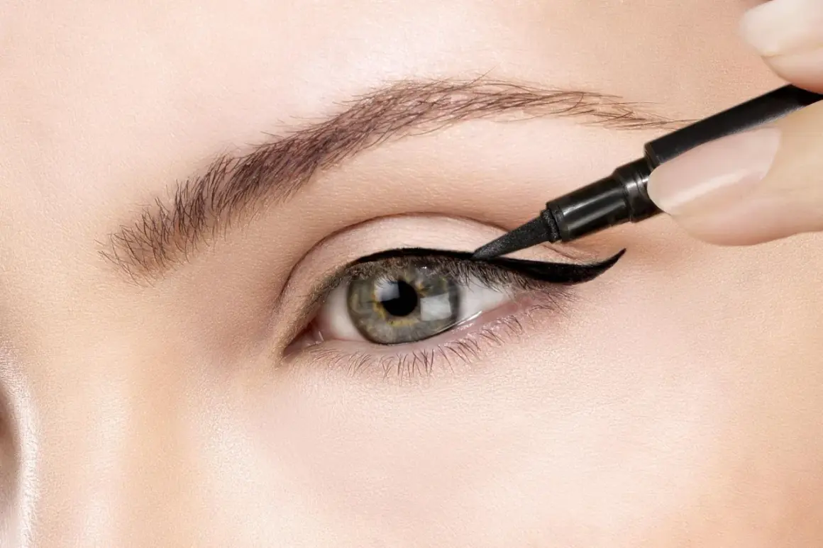 Precyzyjne wykonanie kociego oka makijaż. Czarny eyeliner podkreśla kształt oka, tworząc uwodzicielskie spojrzenie.