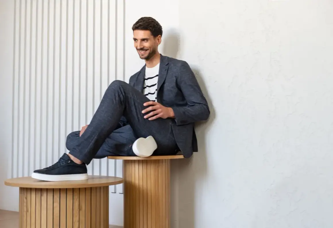 Mężczyzna w granatowym garniturze i białej bluzce w paski, prezentujący styl smart casual męski.