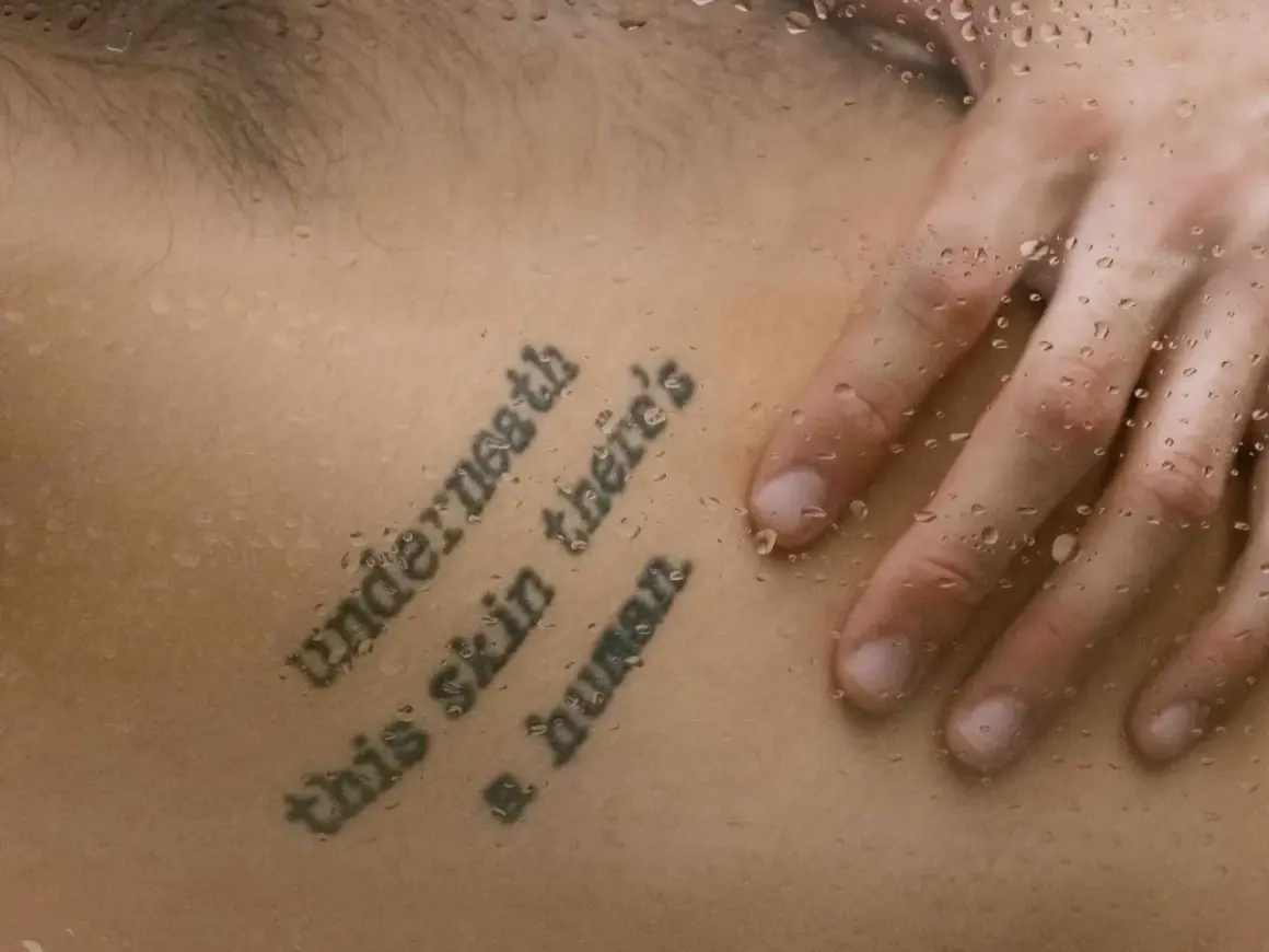 Mądre cytaty na tatuaż: "Underneath this skin there's a human". Dłoń na skórze z kroplami wody.