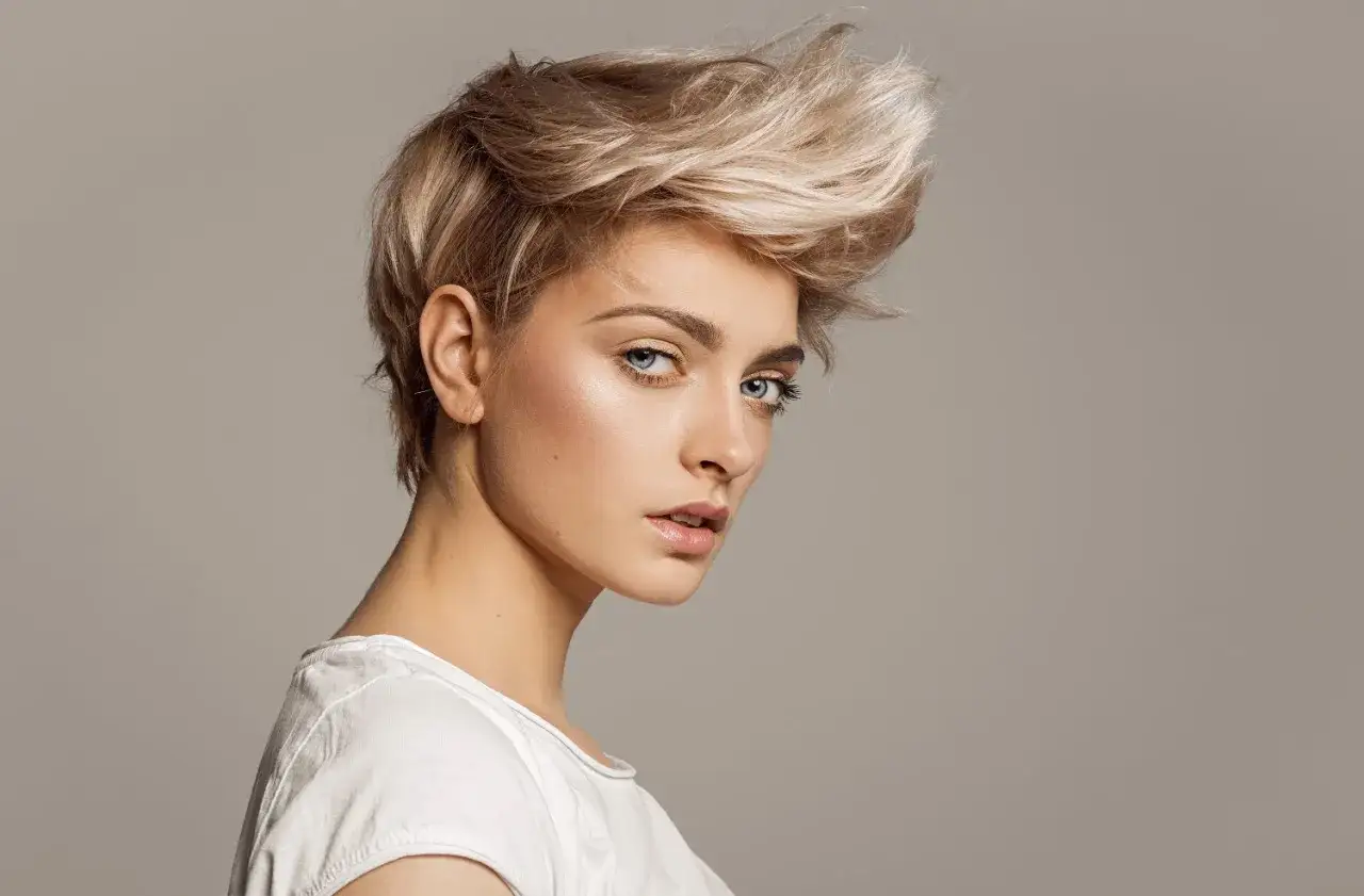 Kobieta z blond, potarganą, krótką fryzurą, prezentująca najnowsze krótkie fryzury damskie.