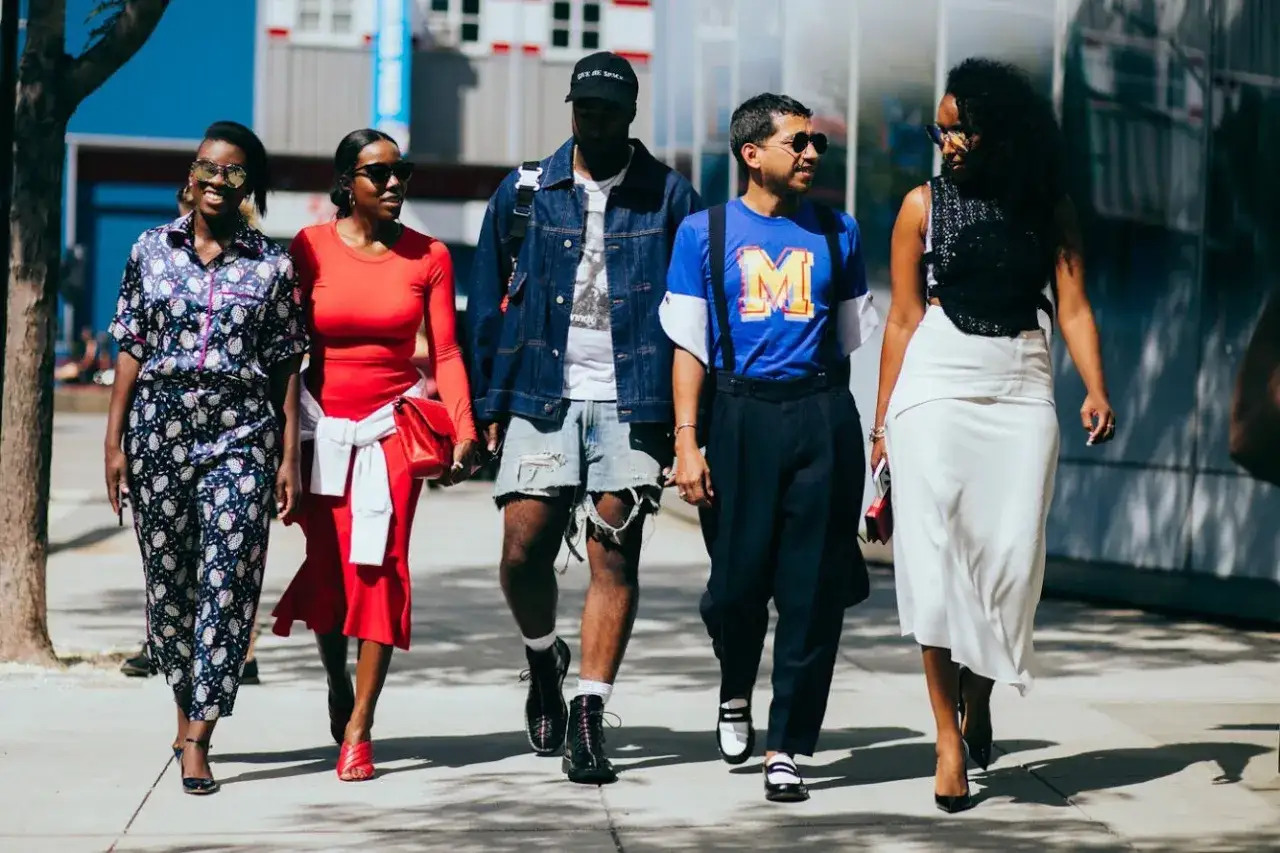Pięć osób idzie ulicą, prezentując różnorodne style. Czy to jest dress code co to?