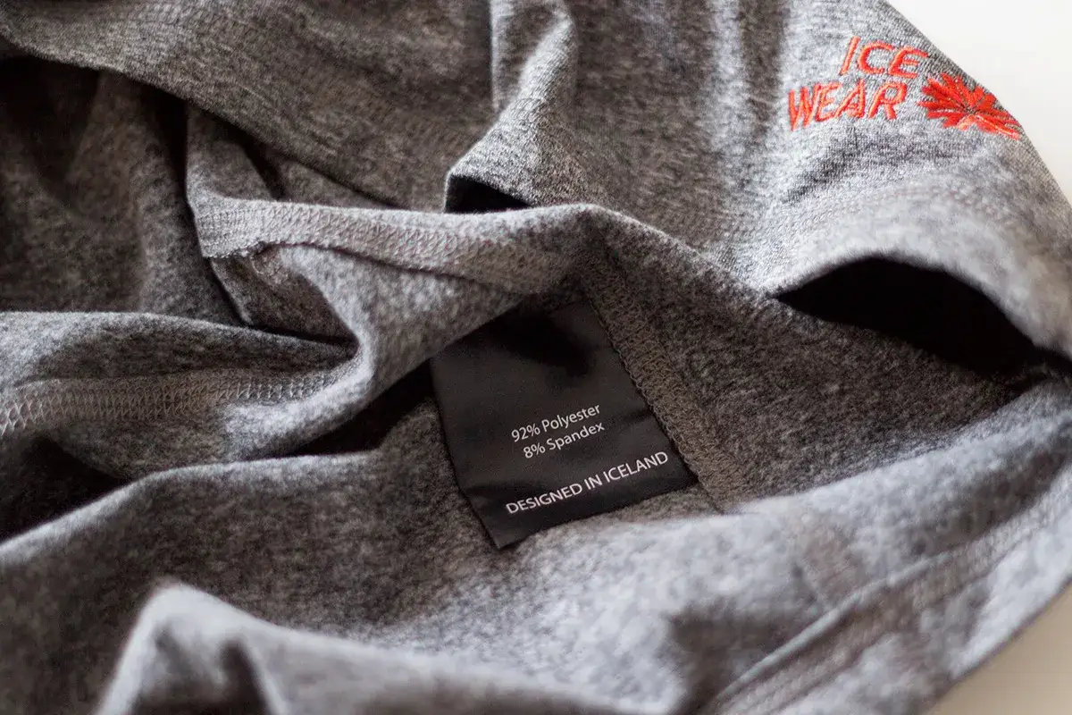Szara koszulka z metką: 92% poliester, 8% spandex. Wyprodukowano na Islandii. Idealna na chłodne dni, bo poliester grzeje lepiej niż poliamid.