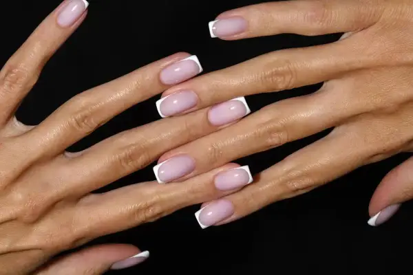 Delikatne paznokcie na jesień w stylu francuskiego manicure. Różowa baza i białe końcówki dodają elegancji.