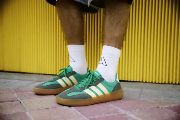 Zielone sneakersy Adidas z żółtymi paskami i brązową podeszwą. Idealne na 18 stopni, gdy chcesz wyglądać stylowo i czuć się komfortowo.