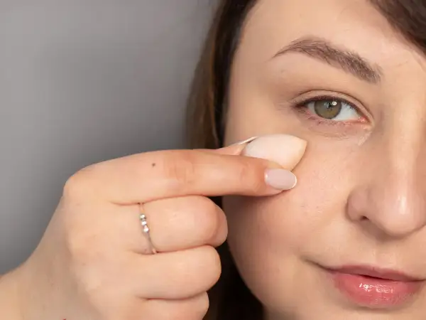 Delikatne muśnięcie gąbeczką to klucz do tego, jak nakładać korektor pod oczy, by uzyskać naturalny efekt.