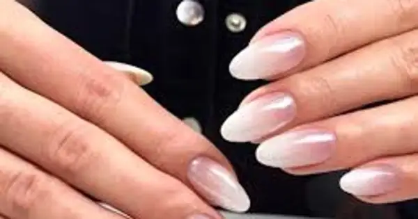 Eleganckie paznokcie ombre french w odcieniach bieli i różu, subtelnie przechodzące w perłowy blask.